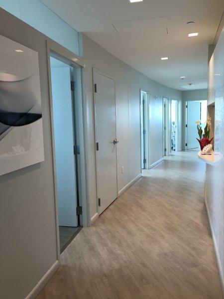 A hallway with white walls and wooden floors.