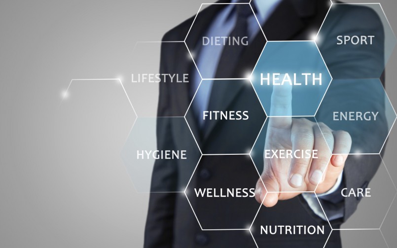 A man in suit and tie pointing to the word health.