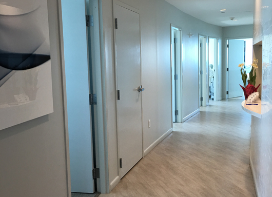 A hallway with two doors and a wall.