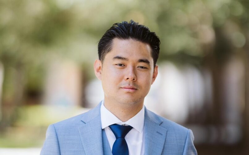 A man in a suit and tie standing outside.